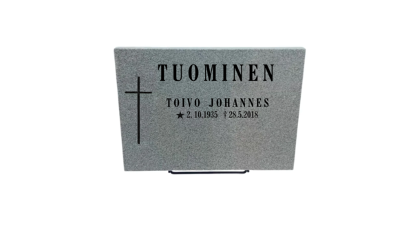 Hautalaatta 1 + teline Harmaa graniitti Korkeus 30 cm, leveys 40cm, vahvuus 3 cm. Pintakäsittelyt: Etupinta hiottu, sivut ja päällinen ja tausta sahattu